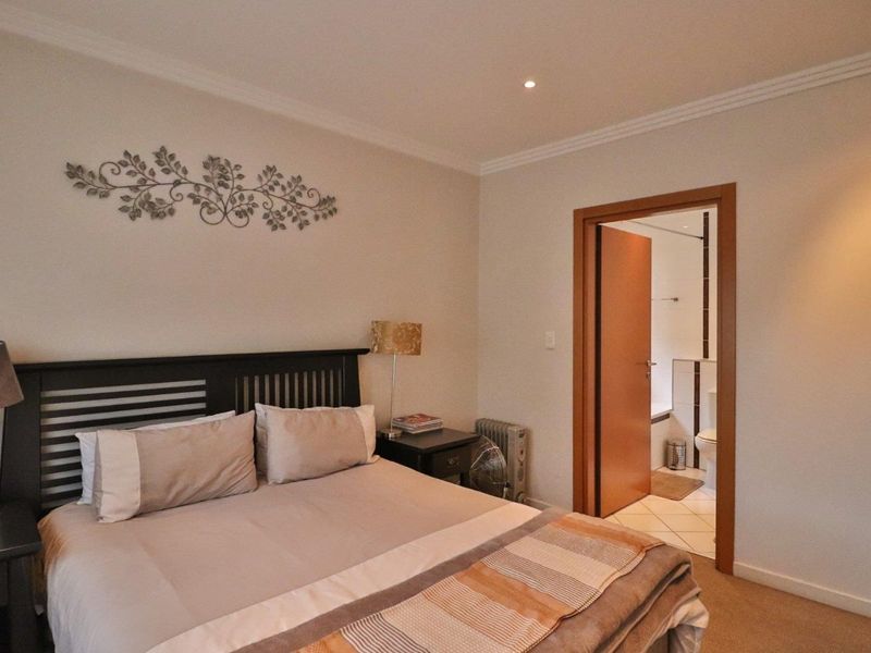 A well-maintained bedroom featuring neutral walls, coving, recessed lighting, and direct access to an en-suite bathroom.