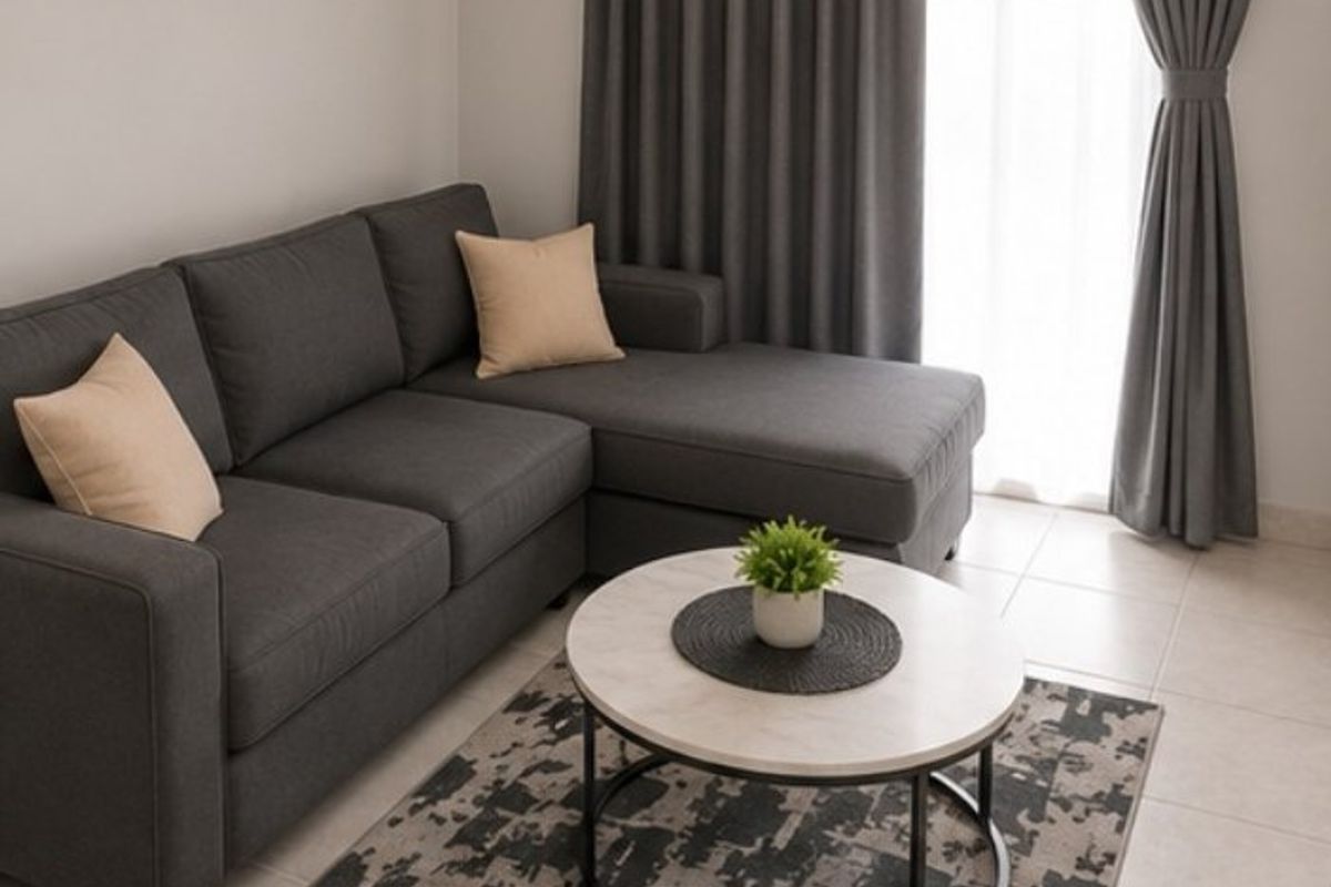A well-lit living room area featuring neutral tiled flooring and floor-to-ceiling curtains, providing a clean and modern foundation for the space.