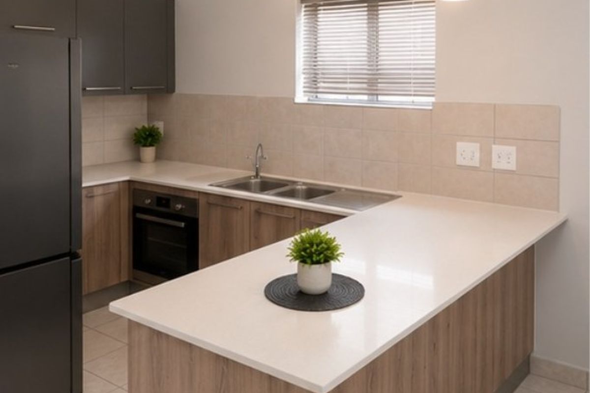 Modern kitchen featuring wood-finish cabinetry, stone countertops, a double sink, built-in oven, and a functional breakfast bar layout.