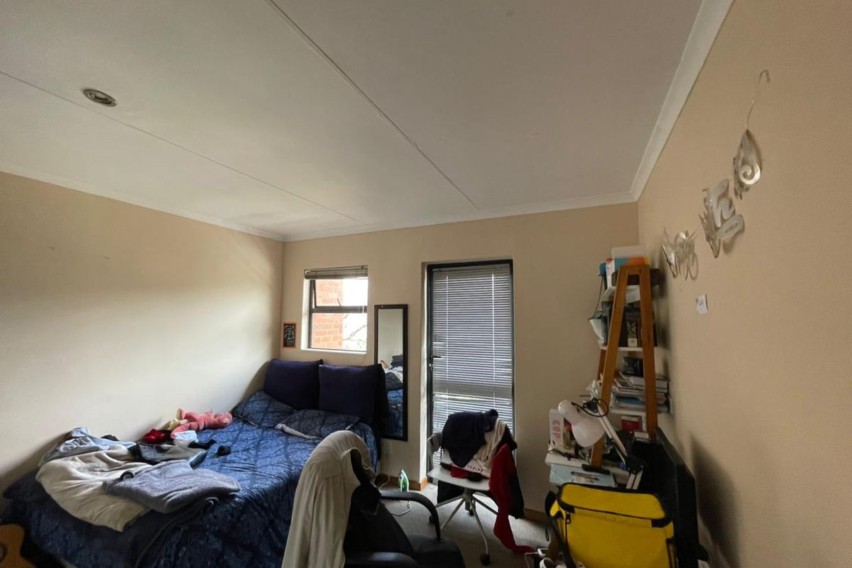 A standard bedroom featuring neutral wall finishes, recessed ceiling lighting, and window blinds, providing a functional space for rest.