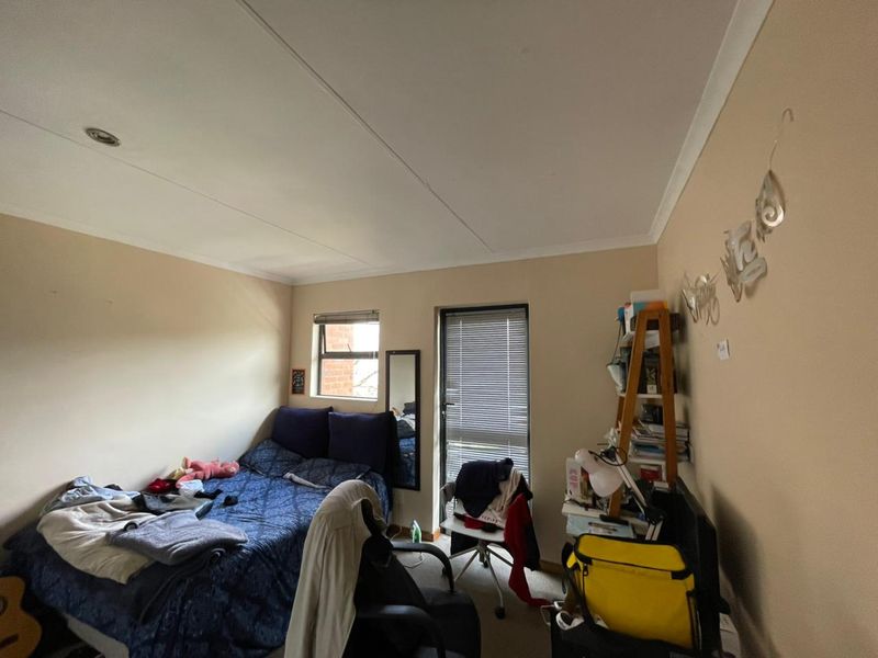 A standard bedroom featuring neutral wall finishes, recessed ceiling lighting, and window blinds, providing a functional space for rest.