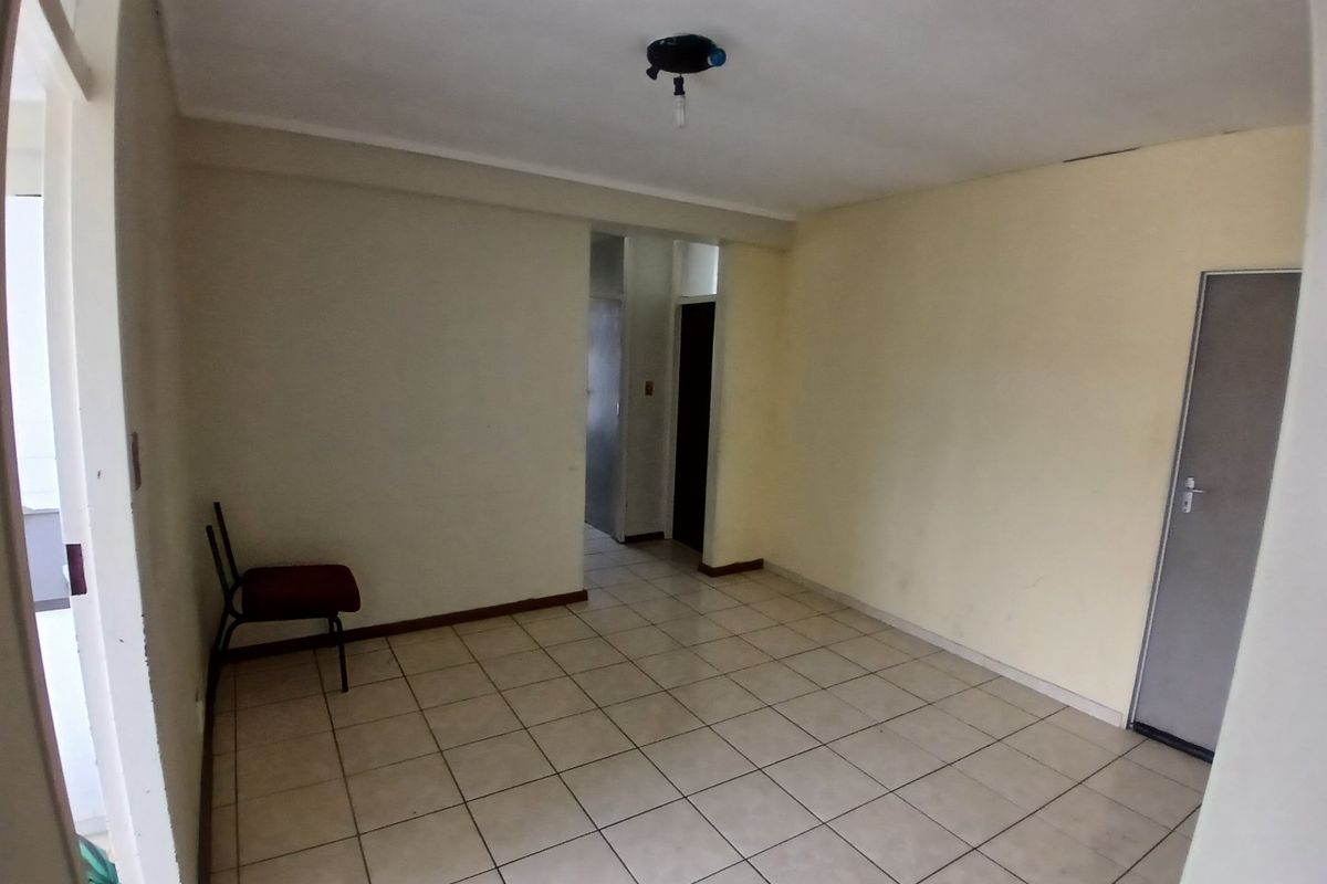 An empty living area featuring ceramic floor tiles and neutral wall finishes, offering a blank canvas for potential interior design updates.