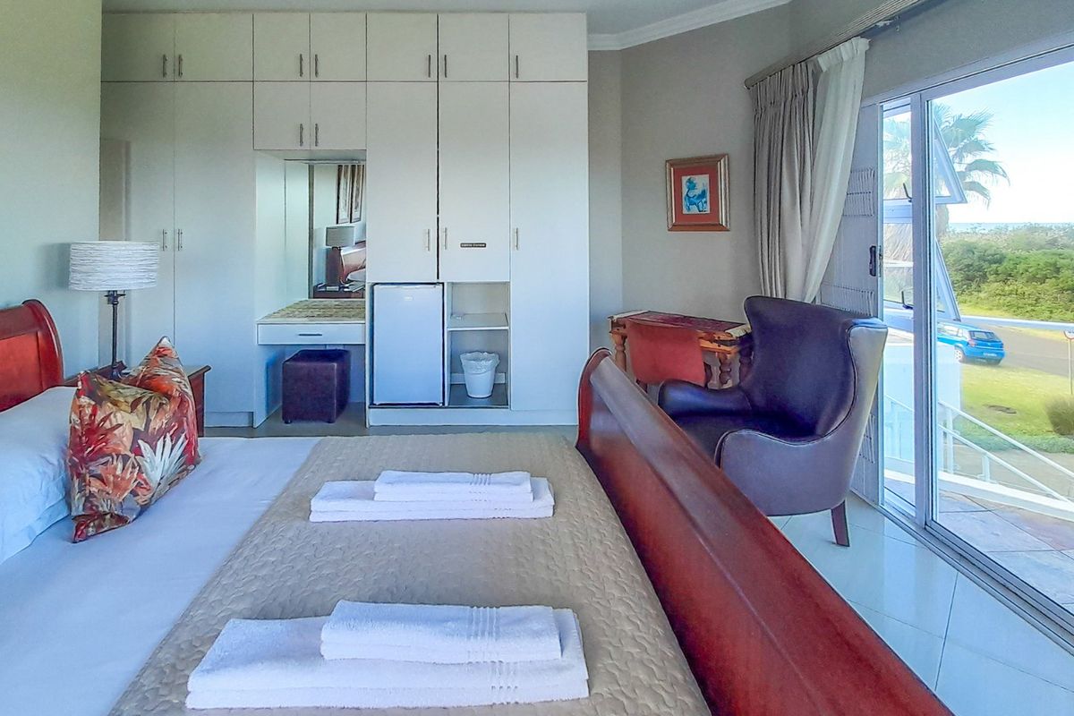 Spacious bedroom featuring extensive built-in cabinetry, a dedicated vanity area, and large sliding glass doors providing natural light and access to the exterior.
