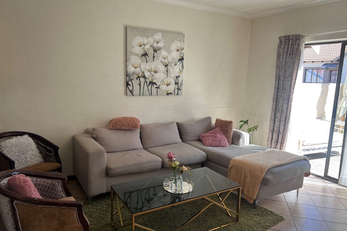 A living room featuring tiled flooring and a sliding glass door providing access to the outdoor area.