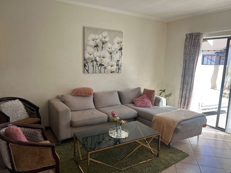 A living room featuring tiled flooring and a sliding glass door providing access to the outdoor area.