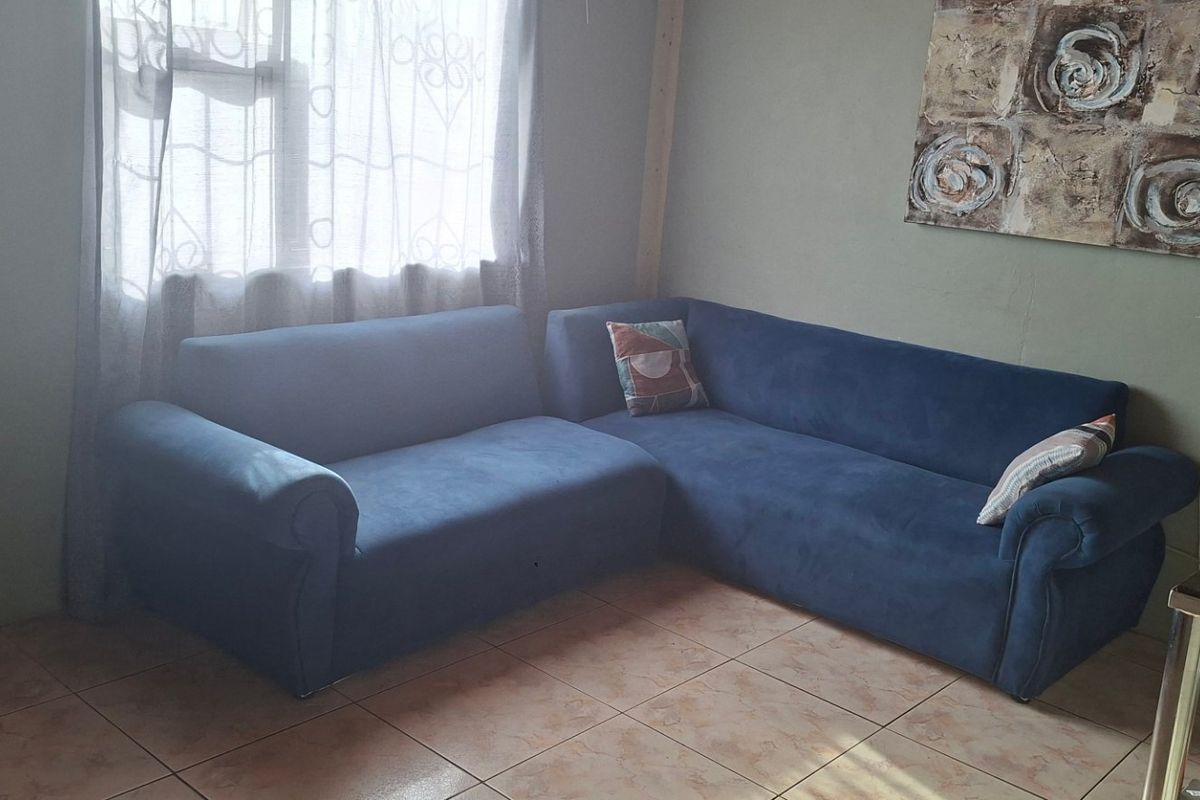 A living room area featuring tiled flooring and natural light from a window.