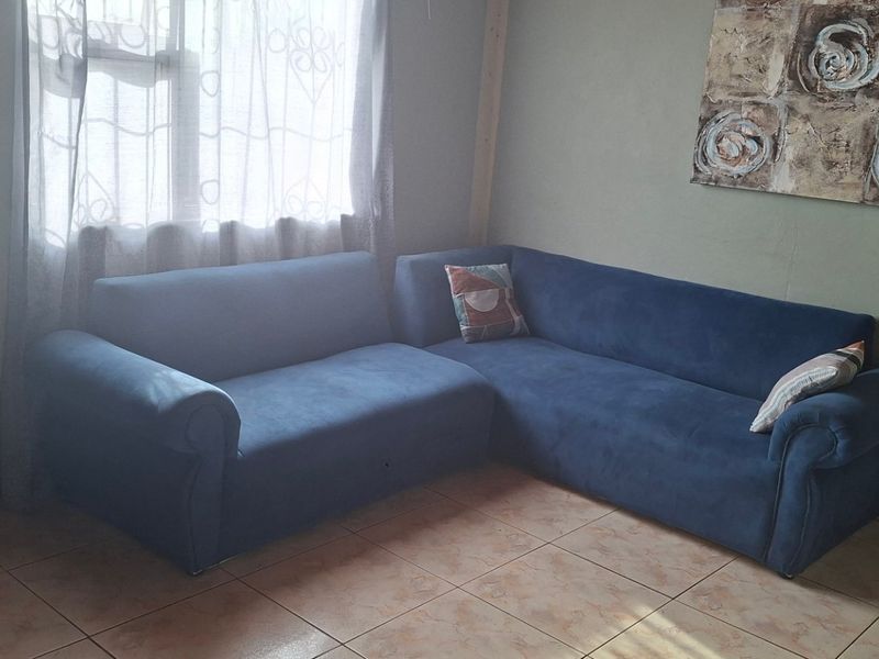 A living room area featuring tiled flooring and natural light from a window.