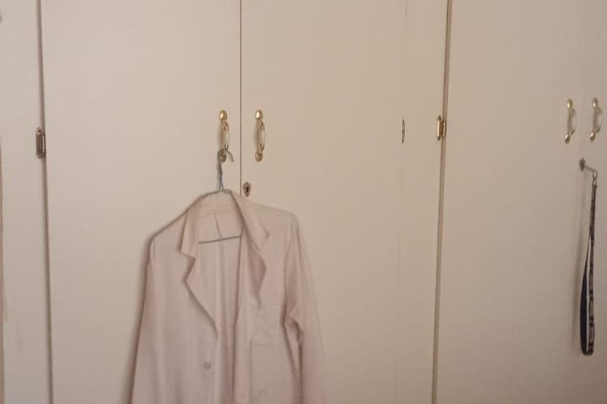 A bedroom featuring built-in cupboards and tiled flooring.