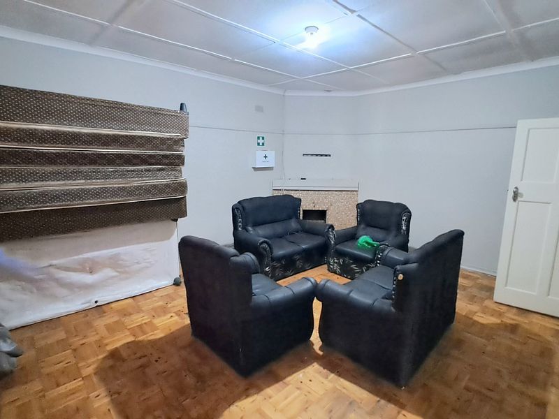 A living room featuring parquet flooring, a fireplace, and coved ceilings, offering a blank canvas for renovation and interior design updates.