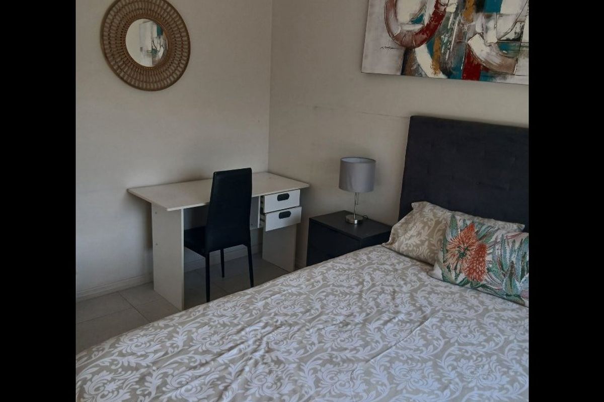 A functional bedroom featuring tiled flooring and neutral wall finishes, providing a comfortable and practical living space.