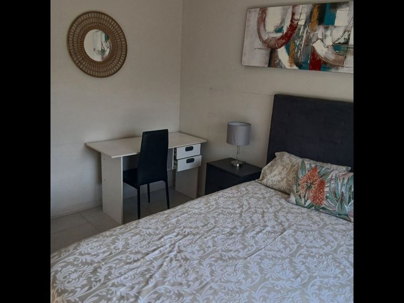 A functional bedroom featuring tiled flooring and neutral wall finishes, providing a comfortable and practical living space.