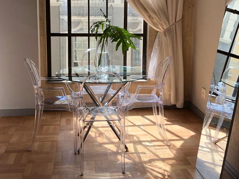 A bright dining area featuring classic parquet flooring and a large multi-pane window that allows for ample natural light.