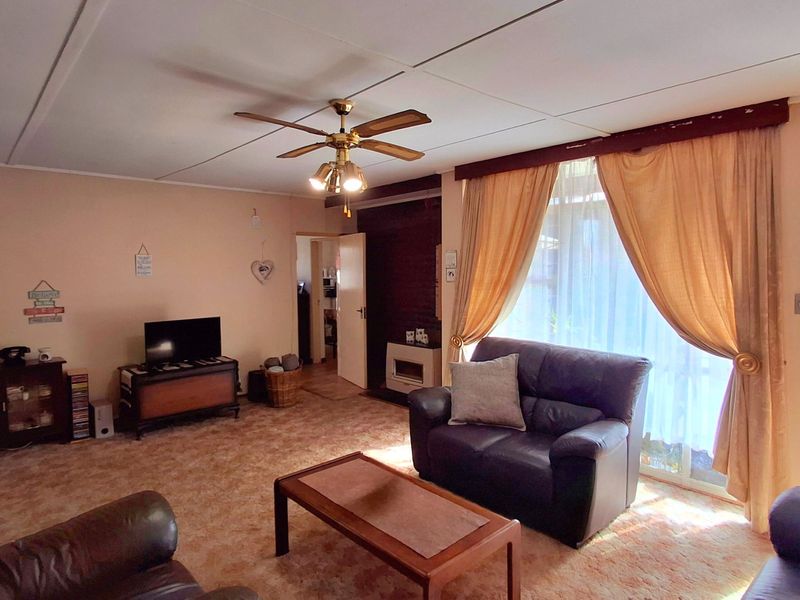 Spacious living room featuring a built-in fireplace, ceiling fan, and sliding glass door access to the exterior.