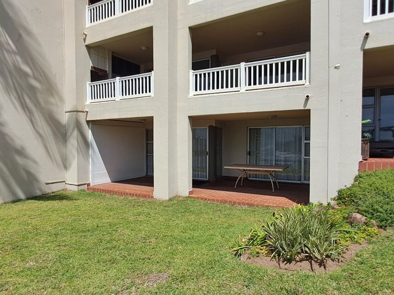 Ground floor apartment featuring covered patios with tiled flooring, sliding glass doors, and direct access to the communal garden area.