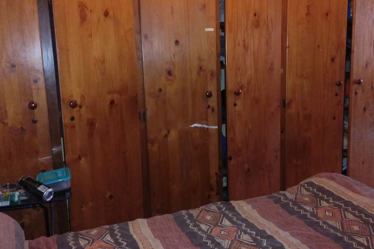 A bedroom featuring extensive built-in wooden cabinetry providing ample storage space.