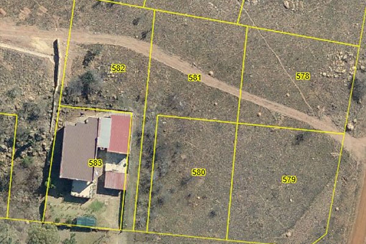 Aerial view of residential land parcels with cadastral boundary overlays, showing vacant plots and an existing dwelling on the adjacent property.