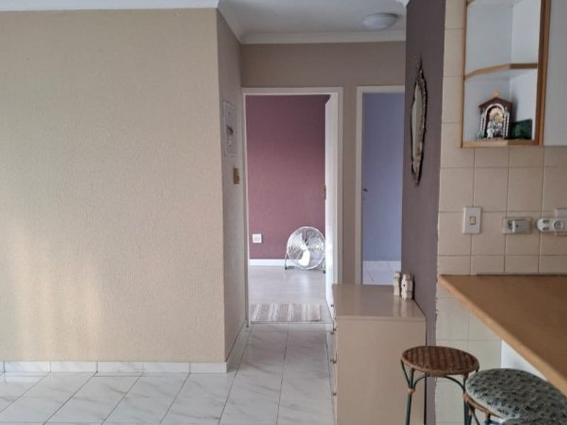 Open plan living area featuring tiled flooring, a breakfast counter with built-in cabinetry, and access to adjacent rooms.