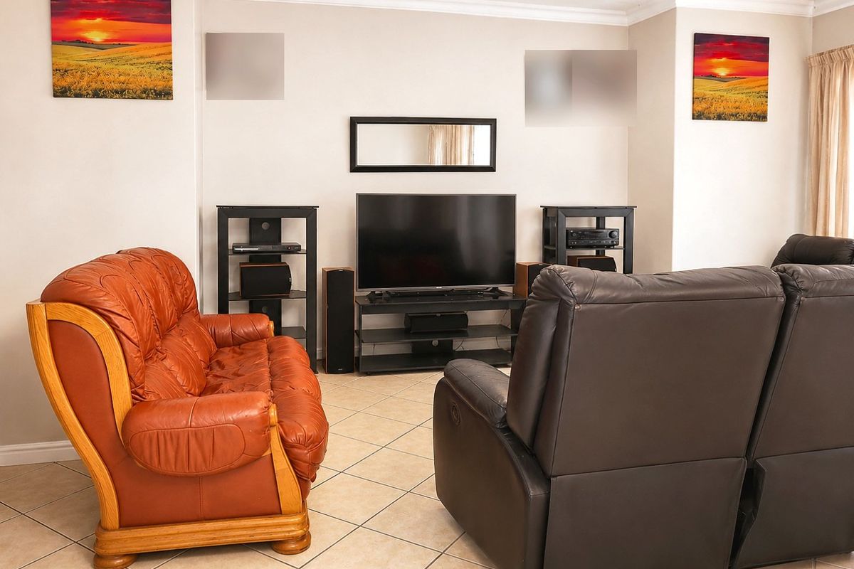 A comfortable living room featuring neutral wall tones, ceramic floor tiles, and coved cornice detailing, providing a functional and well-maintained space.