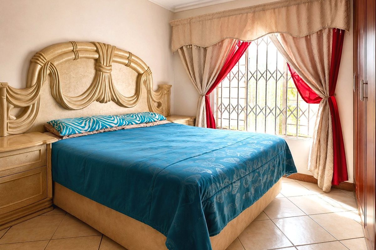 A bedroom featuring tiled flooring, a built-in wardrobe, and a window fitted with a security gate.