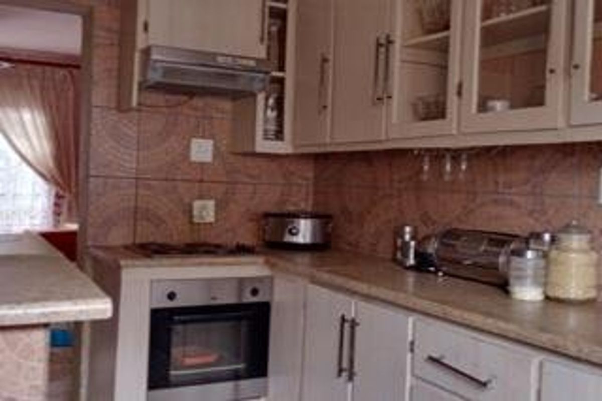 A functional kitchen featuring built-in cabinetry, a gas hob, an integrated oven, and a tiled backsplash with laminate countertops.
