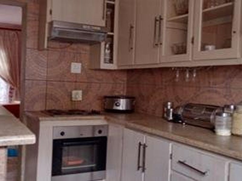 A functional kitchen featuring built-in cabinetry, a gas hob, an integrated oven, and a tiled backsplash with laminate countertops.