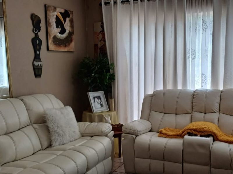 A cozy living room area featuring tiled flooring and large window curtains, providing a comfortable space for relaxation.