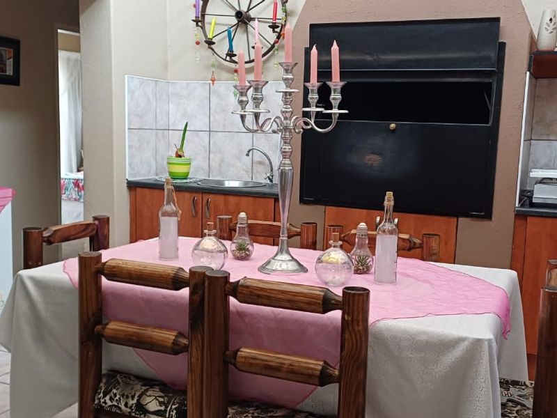A functional kitchen area featuring built-in wooden cabinetry, tiled backsplash, and a built-in oven, providing a practical space for meal preparation.