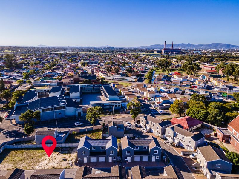 Aerial view of a residential area highlighting a vacant plot of land situated within an established housing complex.