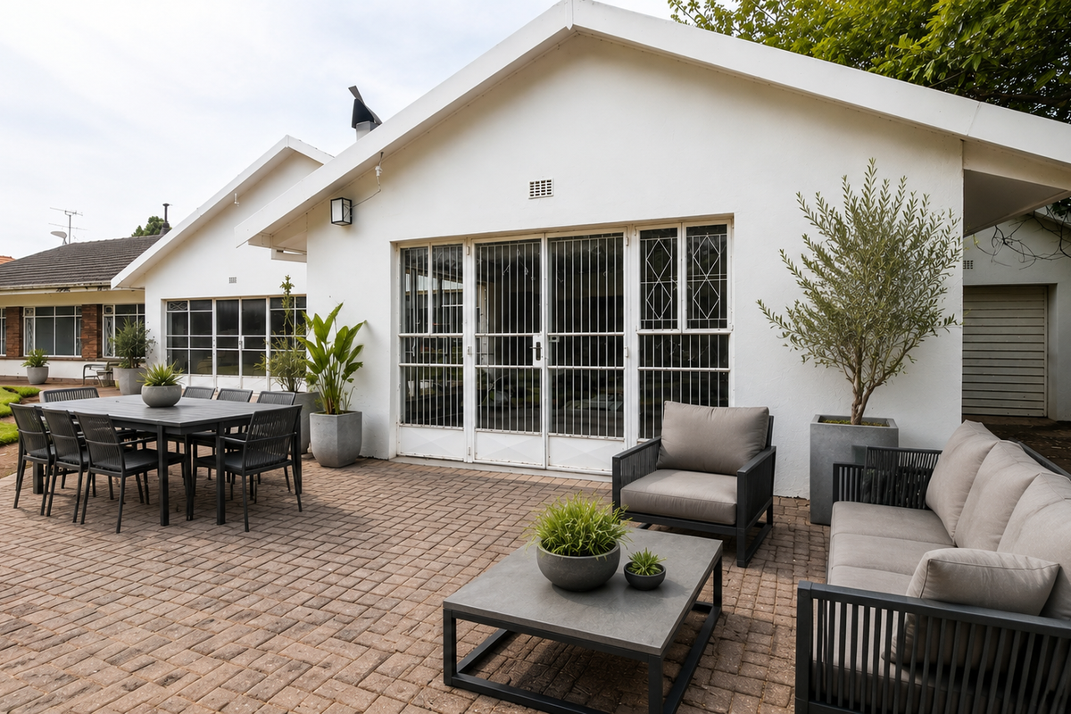A well-maintained rear patio area featuring paved flooring, secure sliding doors, and external lighting, providing a functional outdoor entertainment space.