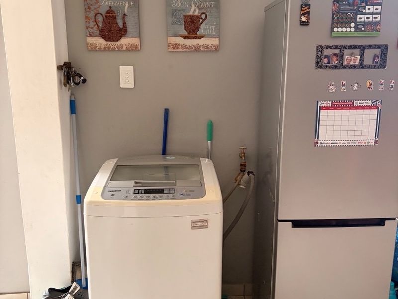 A functional laundry area featuring tiled flooring and dedicated plumbing connections for a washing machine.