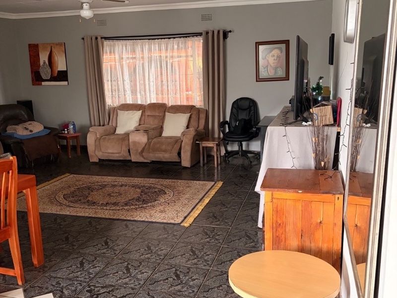 Spacious living room featuring tiled flooring and a ceiling fan, offering a comfortable and functional layout for relaxation.