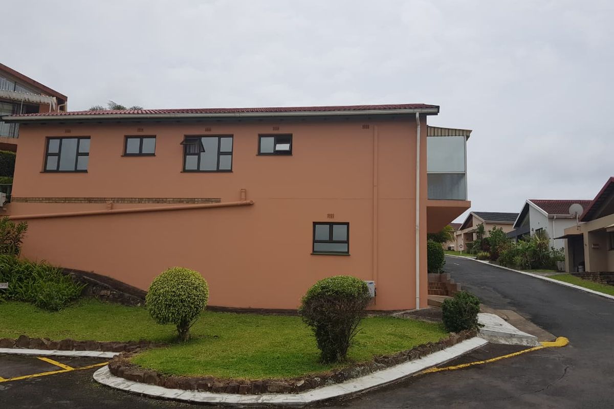 Side and rear elevation of a townhouse featuring a tiled roof, aluminium window frames, and an enclosed balcony area.