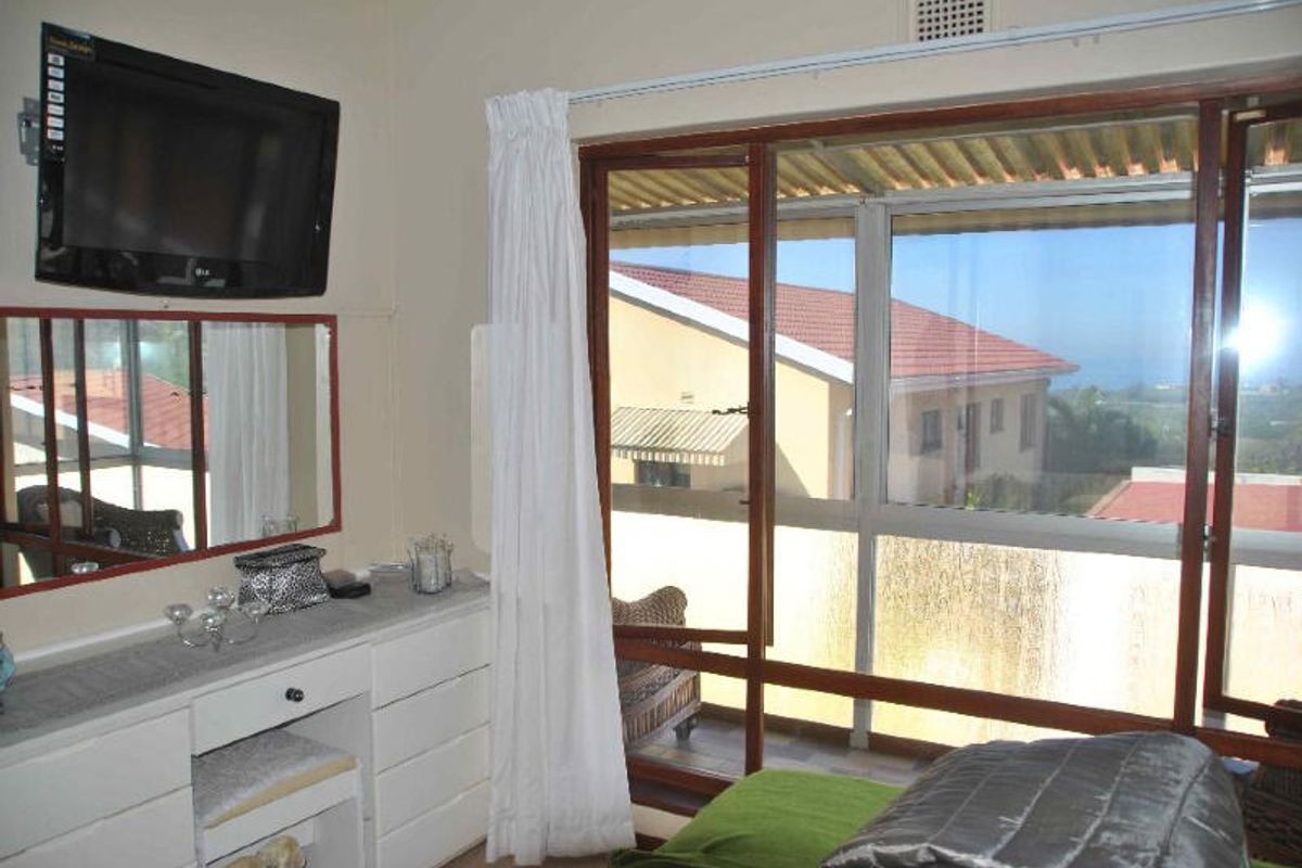 Bedroom featuring a large sliding glass door with access to an outdoor balcony area and a built-in ventilation grille.