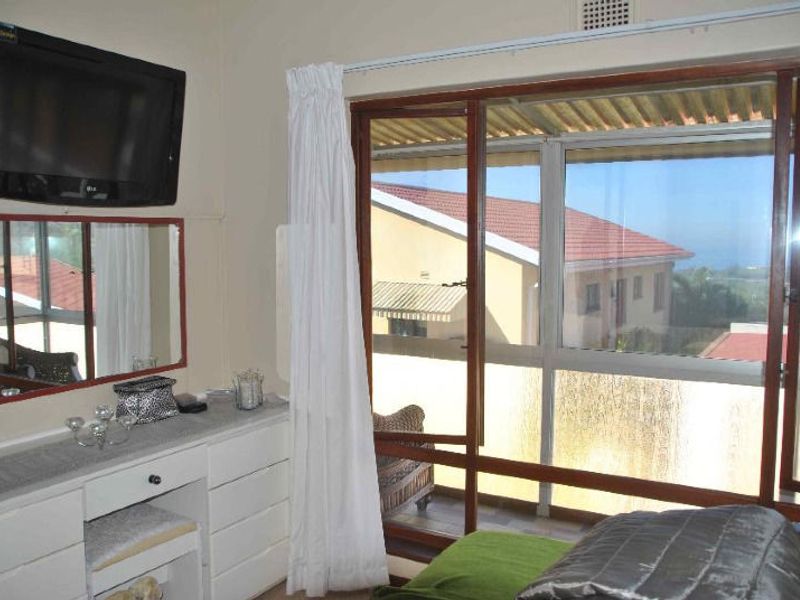Bedroom featuring a large sliding glass door with access to an outdoor balcony area and a built-in ventilation grille.