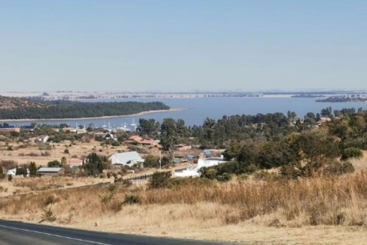 A scenic landscape view overlooking a large water body and surrounding residential area.