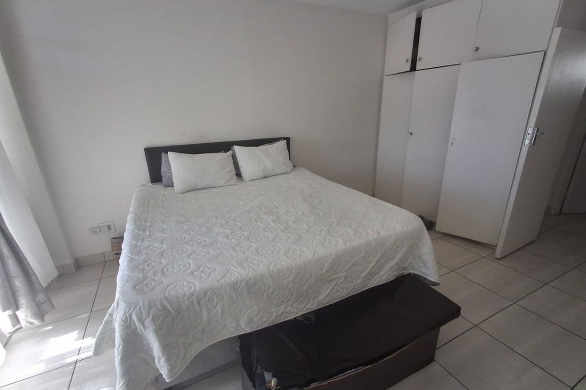 A bedroom featuring tiled flooring and built-in cupboards, providing functional storage space.