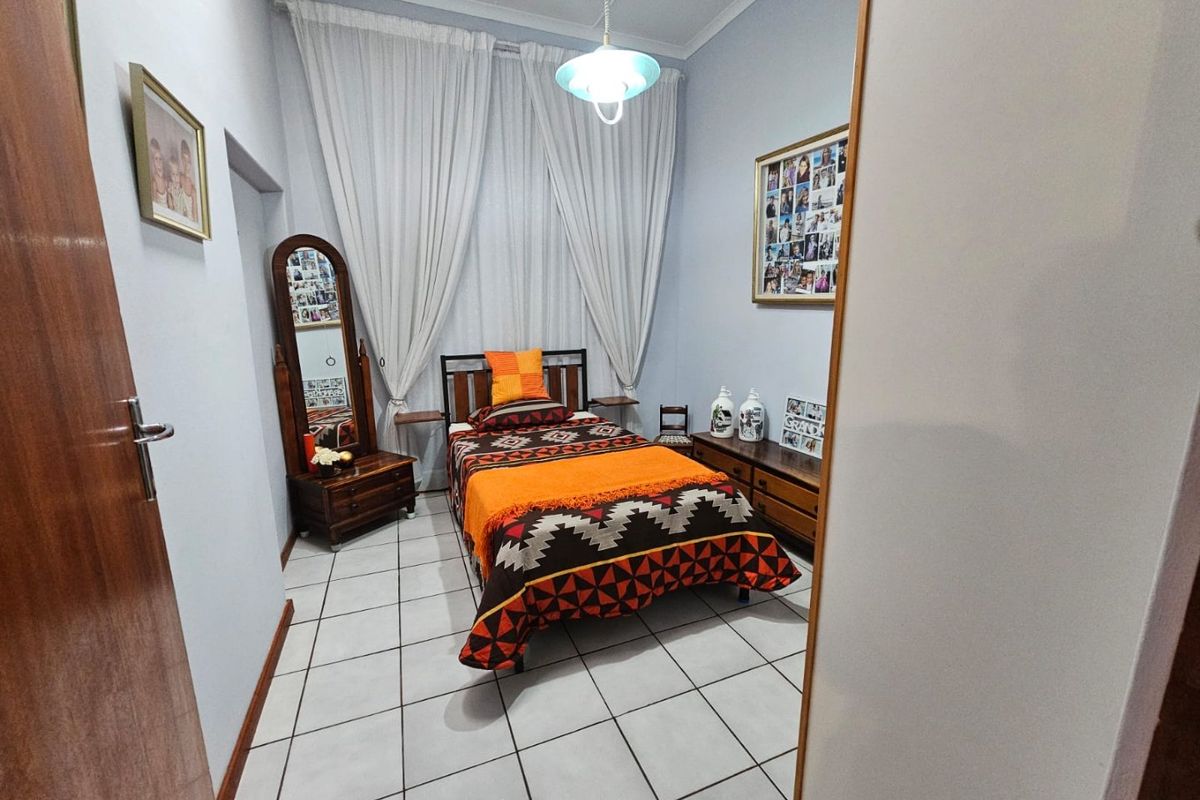 A functional bedroom featuring tiled flooring and neutral wall finishes, providing a clean and simple space.