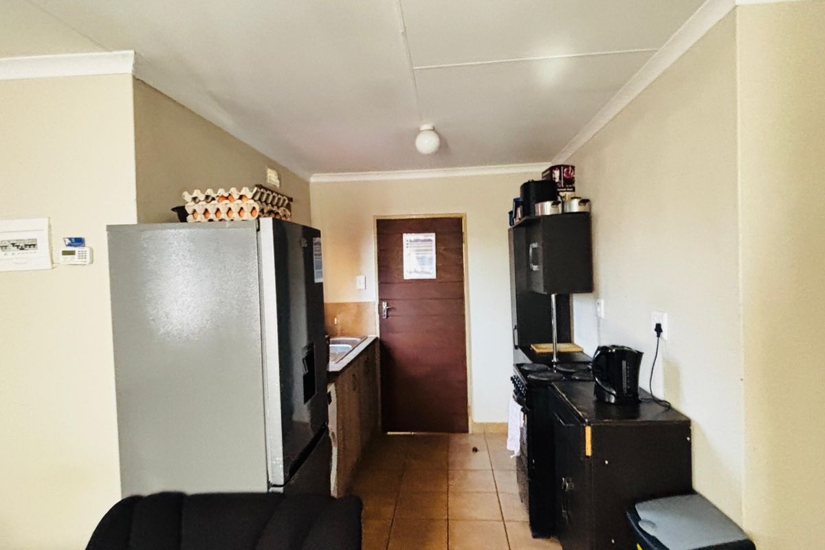 A functional kitchen area featuring tiled flooring, built-in cabinetry, and a sink, providing a practical space for meal preparation.