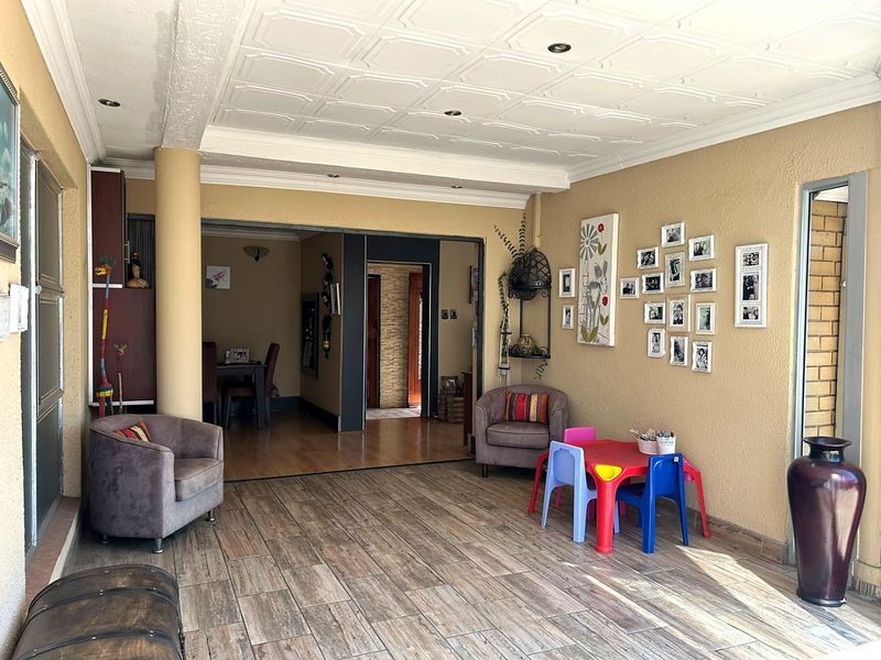 A spacious covered patio area featuring tiled flooring, recessed lighting, and decorative ceiling panels, providing seamless access to the interior living spaces.