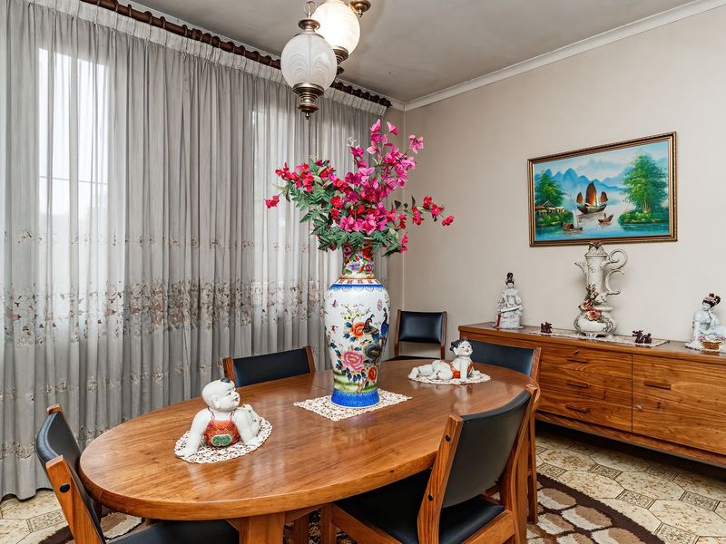 A traditional dining room featuring tiled flooring, coving, and pendant lighting, offering a functional space for family meals and entertaining.