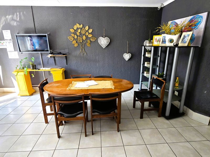 A dining area featuring tiled flooring and a dark textured feature wall, providing a functional space for meals.