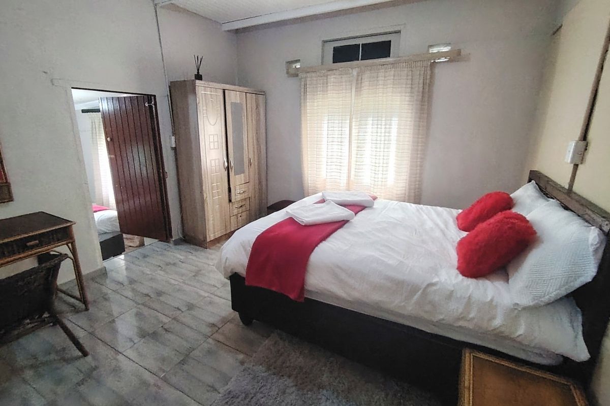 A bedroom featuring tiled flooring and a built-in wardrobe, showing signs of wear and requiring cosmetic updates to improve its overall condition.