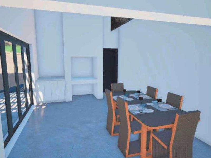 A covered patio area featuring concrete flooring, a built-in braai, and large sliding glass doors providing access to the outdoor space.