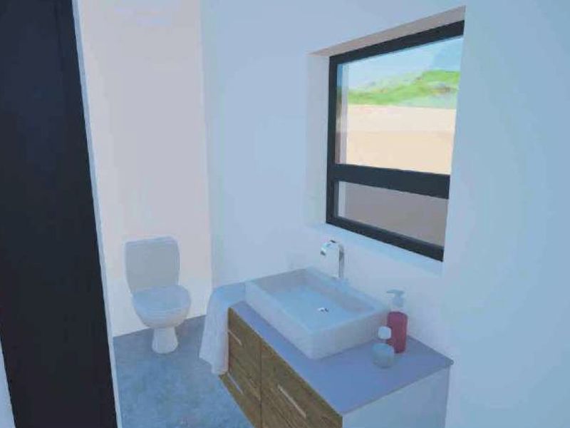 A modern bathroom featuring a vanity cabinet with a vessel sink, a toilet, and a window providing natural light.
