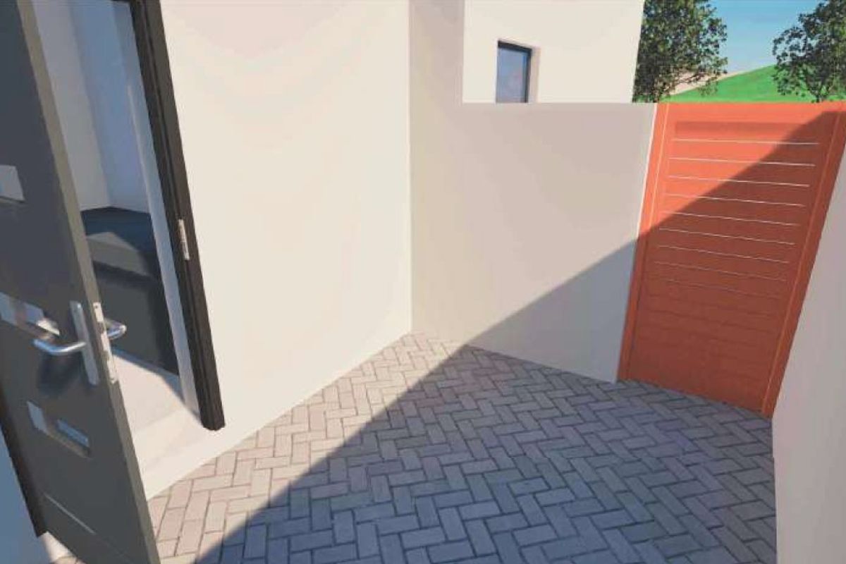 A small paved courtyard area featuring a boundary wall and a gate, providing a private outdoor space.