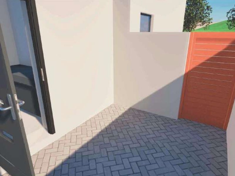 A small paved courtyard area featuring a boundary wall and a gate, providing a private outdoor space.