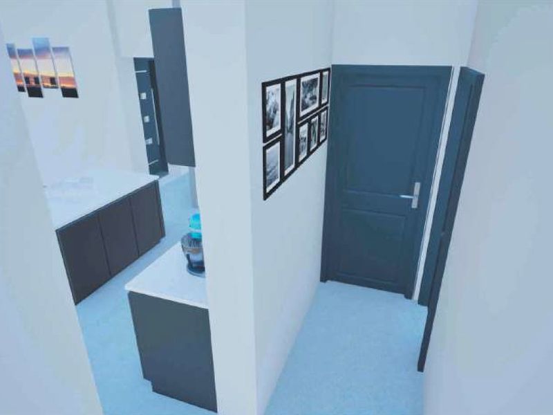 A modern kitchen area featuring dark cabinetry and a central island, viewed from an adjacent hallway.