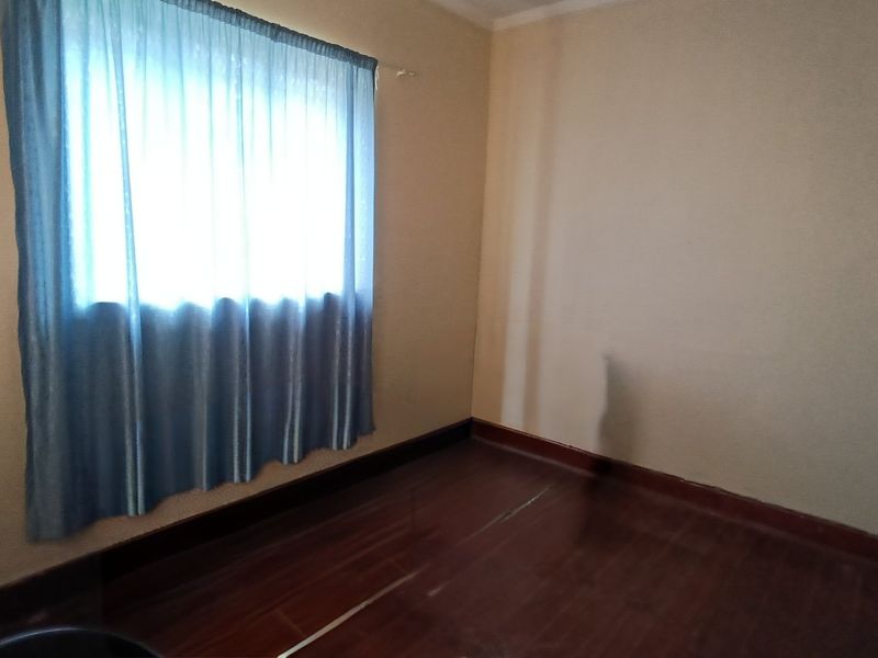 An empty bedroom featuring hardwood flooring and neutral wall tones, providing a blank canvas for potential interior design updates.