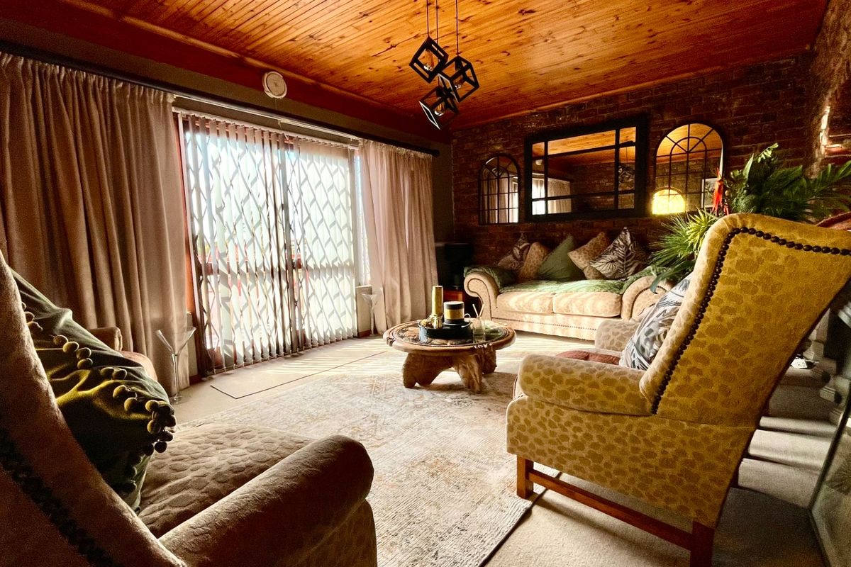 Cozy living room featuring a warm timber ceiling, exposed brick wall, and large sliding glass doors providing access to the exterior.