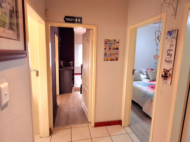 A functional hallway connecting multiple rooms, featuring tiled flooring and access to bedroom and bathroom areas.